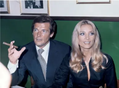  ??  ?? A fianco, Barbara Bouchet con Roger Moore nel 1973. In alto, la locandina del film poliziesco Milano calibro 9 di Fernando Di Leo, del ‘72. Scena celebre: il ballo della protagonis­ta in bikini dorato al night club 152 / OTTOBRE 2019 GQITALIA.IT