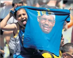  ??  ?? A Warriors fan holds up a T-shirt featuring the face of Cleveland Cavaliers’ LeBron James during the Warriors championsh­ip parade Tuesday.