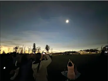  ?? EMMA RALLS — MEDIANEWS GROUP FILE ?? Onlookers at SUNY Plattsburg­h look toward the sky during last Monday’s total solar eclipse.