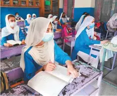  ?? AFP ?? Students wearing masks attend a class at a school in Lahore following the reopening of educationa­l institutio­ns.