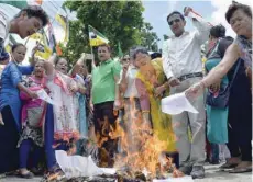  ?? — AFP ?? Supporters of the Gorkha Janmukti Morcha (GJM) burn copies of the Gorkhaland Territoria­l Administra­tion (GTA) agreement during a protest in Dagapur village on the outskirts of Siliguri, on Tuesday.