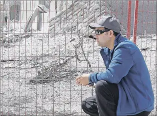  ?? CP PHOTO ?? Farid El-Hayouni looks at the charred remains of his son’s bike in Fort McMurray, Alta. on Friday.