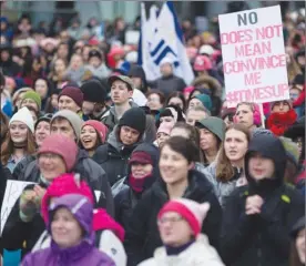  ?? The Canadian Press ?? A woman holds a sign as thousands of people attend a women’s march in Vancouver, one of many staged across North America on Saturday.