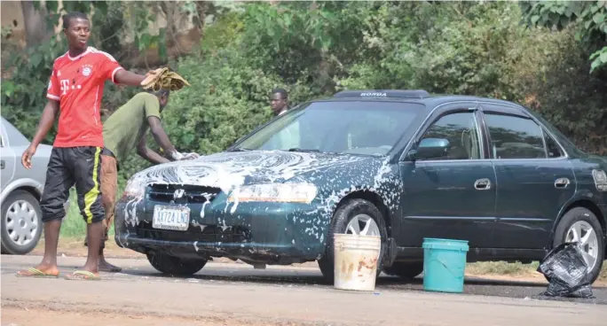  ?? PHOTO
IKECHUKWU IBE ?? Roadside car washers at Garki yesterday.