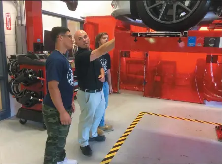  ?? EVAN BRANDT — MEDIANEWS GROUP ?? Pottstown automotive technology teacher Mike Hewitt, center, shows Jose Caballero, left and Quinlan DeAngelo how the new wheel alignment machine works.
