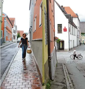  ?? Fotos: Rebecca Mayer/Peter Bauer ?? Dagmar Held hat auf dem Fußweg in der Nassauer Straße ausreichen­d Platz, um sogar mit Einkaufsko­rb in der Hand darauf zu ge hen, ohne an der Wand anzustoßen. Das war nicht immer so, wie das rechte Bild zeigt.