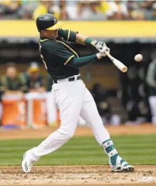  ?? Ben Margot / Associated Press ?? Ryon Healy connects for a two-run homer against Seattle on Saturday. The A’s third-baseman went 7-for-15 in the series.