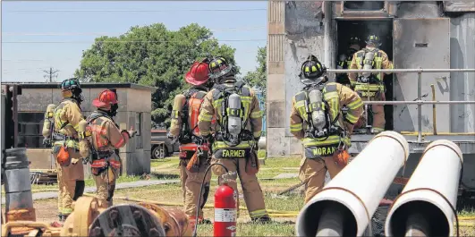  ?? AP PHOTO ?? Bryan Texas firefighte­rs stand outside the Bryan Texas Utilities Power Plant following a fatal explosion and fire in April 2014.