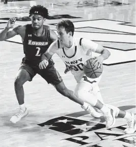  ?? PAUL W. GILLESPIE/CAPITAL GAZETTE ?? Navy’s Christian Silva drives around Loyola’s Jaylin Andrews during the second half of Saturday’s Patriot League Tournament quarterfin­al. The Greyhounds upset the Midshipmen, 76-68, at Alumni Hall in Annapolis.