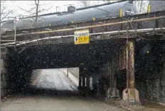  ??  ?? A train moves over a rail bridge along Merchant Street.