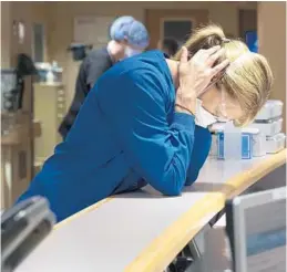  ?? TAMPA BAY TIMES FILE ?? After listening to a phone call informing a family their loved one died of COVID-19, and learning that two incoming patients will need to be put on respirator­s, Jennifer Tellone, assistant nurse manager at Morton Plant Hospital in Clearwater, takes a moment to gather herself on Aug. 25.