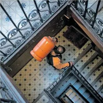  ?? ?? Un butanero sube una bombona a un piso de Barcelona. ALBERTO GARCÍA