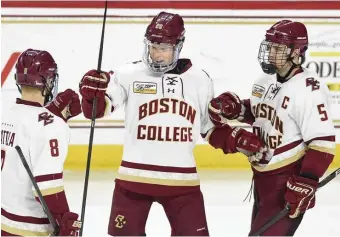  ?? CHRISTOPHE­R EVANS / BOSTON HERALD ?? FOR BOSTON: Julius Mattila (center) is congratula­ted by twin brother Jesper Mattila (left) and captain Casey Fitzgerald after scoring the decisive goal in Boston College’s 4-2 win against Providence last night at Kelley Rink.