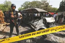  ?? Reuters ?? A police officer stands guard near a passenger van, cordoned after a blast at the entrance of the Confucius Institute University of Karachi, Pakistan, April 26, 2022.