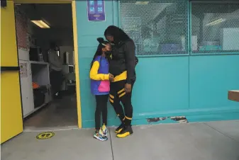  ?? Paul Kuroda / Special to The Chronicle ?? At Merced Heights Playground, Brooklynn Holmon, 9, hugs her mother, Shashona, at a city hub that offers child care as well as academic support and supervisio­n for schoolage children.