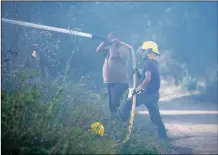  ?? MORGAN TIMMS/Taos News ?? Local volunteer firefighte­rs battle a residentia­l fire Tuesday afternoon (July 7) at 46 Old State Road 3 in Arroyo Hondo.