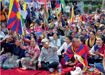  ?? — BUNNY SMITH ?? Tibetans raise slogans to mark the 10th anniversar­y of their uprising against the Chinese government at Parliament Street in New Delhi on Wednesday.