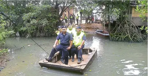  ??  ?? hidden trail: Police using the makeshift ferry during the raid at the squatter settlement near Kampung Kalansanan lama.