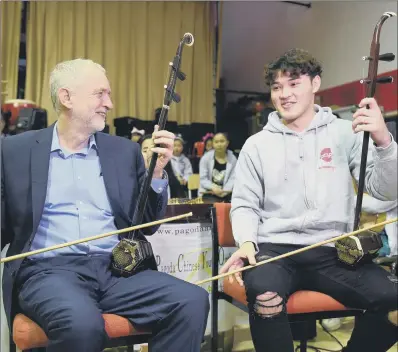  ??  ?? Jeremy Corbyn with Charlie Wardle, 17, playing an erhu during a community visit to Pagoda Arts in Liverpool.