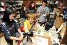  ?? NWA Democrat-Gazette/ANDY SHUPE ?? Kaitlyn Le (left), 14, works with Abby Alexander (center), 14, to make a stop-motion video to illustrate a children’s book as Anh Tran (from left), Ani Watson and Savannah Ball, all eighth-graders at Ramay Junior High, look on during a meeting of The...