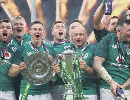  ??  ?? Rory Best celebrates Ireland’s Grand Slam by holding the Six Nations Championsh­ip trophy after beating England on Saturday.