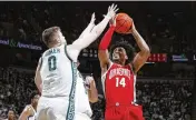  ?? MICH. AL GOLDIS / AP ?? OSU’S Justice Sueing shoots over Michigan State’s Jaxon Kohler Saturday in East Lansing. The Buckeyes lost 9 of 10 Big Ten road games this season,