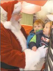  ??  ?? On Dec. 10, Indian Head residents Ben Selckmann, 1, and his brother Owen Selckmann, 3, meet Santa at the Kris Kringle Christmas market on the Charles County Fairground­s.