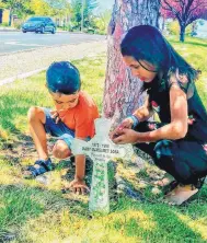  ?? COURTESY OF TERESITA SANCHEZ ?? MaryMargar­et Sosa’s niece and namesake, Ysabel MaryMargar­et Sanchez, 10, and nephew, Eli Sanchez, 4, say a prayer at the descanso that marks the spot near Eubank and Academy where Sosa was killed Aug. 26, 1998.