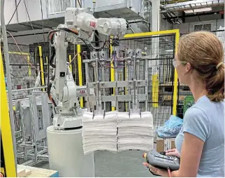  ?? /Reuters/File ?? Softer economy: A researcher at Procter & Gamble’s CoRE Fabric and Home Care Robotics Laboratory works on a robot for handling sheets, in Cincinnati, Ohio, US.