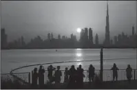  ?? The Associated Press ?? DUBAI: People watch the sunset over the skyline with Burj Khalifa at right, in Dubai, United Arab Emirates, Oct. 7, 2016. The coming film “Geostorm” marks just the latest movie in which Western filmmakers put the commercial capital of the United Arab...