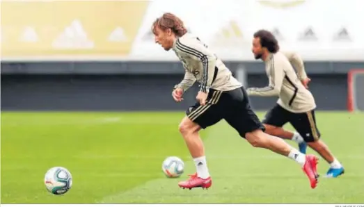  ?? REALMADRID.COM ?? Modric y Marcelo conducen el balón durante la sesión de entrenamie­nto de ayer del Real Madrid.