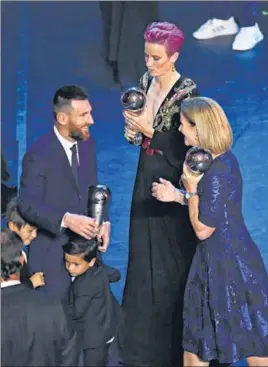  ?? REUTERS ?? Lionel Messi is congratula­ted by USA women's coach Jill Ellis (right) as the FIFA Women's Player of the Year award winner Megan Rapinoe of the US looks on, in Milan on Monday.