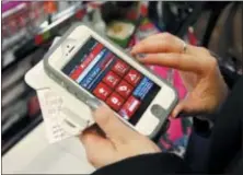  ?? MICHAEL DWYER - ASSOCIATED PRESS FILE PHOTO ?? Tashalee Rodriguez, of Boston, uses a smartphone app while shopping at Macy’s in downtown Boston.