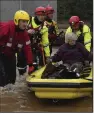  ?? (AP/PA/Andrew Milligan) ?? Members of emergency services help local residents to safety as Storm Babet batters the country in Brechin, Scotland, on Friday.