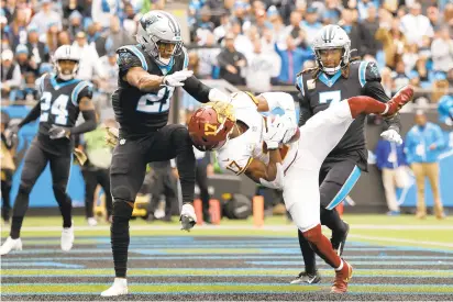  ?? GRANT HALVERSON/GETTY ?? Washington wide receiver Terry McLaurin makes a 12-yard touchdown reception between Carolina’s Jeremy Chinn, left, and Shaq Thompson in the second quarter of Sunday’s game in Charlotte, North Carolina.