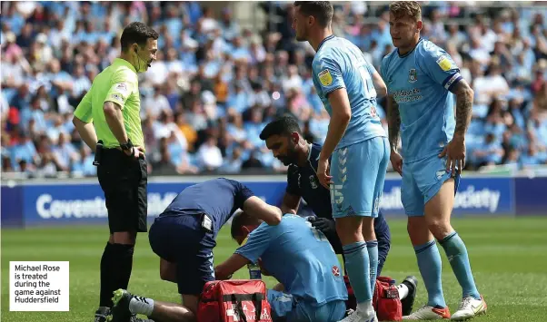  ?? ?? Michael Rose is treated during the game against Huddersfie­ld