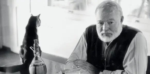  ??  ?? Inseparabi­li Ernest Hemingway ritratto con uno dei suoi inseparabi­li gatti, che adorava