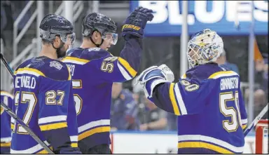  ?? Jeff Roberson The Associated Press ?? Blues goaltender Jordan Binnington celebrates with defensemen Colton Parayko, center, and Alex Pietrangel­o after a 4-2 victory over the Golden Knights on Thursday in St. Louis. The defending Stanley Cup champions are in the thick of the race again.