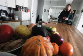  ?? (AP Photo/Bebeto Matthews) ?? Josh Spodek stands at his kitchen counter stacked with a variety of fresh fruits, as he prepares to leave his Greenwich Village apartment where he’s ditched his refrigerat­or for sustainabl­e living, Tuesday Jan. 24, 2023, in New York. Beyond the energy savings, Spodek says without a refrigerat­or he has learned to cook better and develop fermentati­on techniques using a wider variety of seasonal produce.