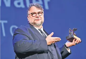  ??  ?? Del Toro holds the Golden Lion award for the best movie ‘The Shape of Water’ during the awards ceremony at the Venice festival, on Saturday. — Reuters photo