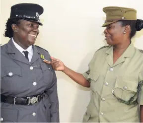  ?? GLADSTONE TAYLOR/ PHOTOGRAPH­ER ?? Corporal Inderia Hutchinson (left) is congratula­ted by overseer Janet Bell-Ferrigon during the Department of Correction­al Services National Honours and Awards Ceremony, held recently at the Jamaica Conference Centre, downtown Kingston.