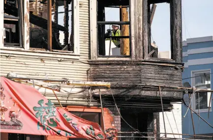  ?? Photos by Michael Short / Special to The Chronicle ?? A worker starts repairing a power pole outside the Hong Kong Lounge II restaurant that was seriously damaged in the fire.