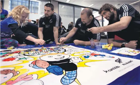  ?? Picture / Brett Phibbs ?? Alana Blow gets Dane Coles, Tony Woodcock and Sam Whitelock involved with some colouring-in yesterday.