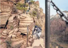  ??  ?? Hikers used the chains along a portion of the Angels Landing trail in Zion National Park in Utah.