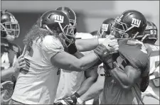  ?? JULIO CORTEZ/AP PHOTO ?? Giants offensive tackle Adam Bisnowaty, left, and defensive end Romeo Okwara fight after running a play Thursday at training camp.
