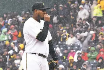  ?? Peter Diana/Post-Gazette ?? Pirates pitcher Ivan Nova pauses during a brief snow squall Friday at PNC Park.