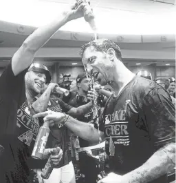  ?? ROB SCHUMACHER/THE REPUBLIC ?? Diamondbac­ks starting pitcher Merrill Kelly pours beer over general manager Mike Hazen after clinching a wild-card spot.