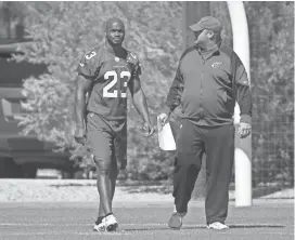  ?? MICHAEL CHOW/AZCENTRAL SPORTS ?? Cardinals running back Adrian Peterson talks with running backs coach Freddie Kitchens during practice in Tempe on Wednesday.