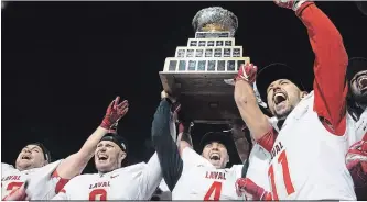  ?? JACQUES BOISSINOT THE CANADIAN PRESS ?? Laval University Rouge et Or quarterbac­k Hugo Richard, second from right, flanked by, from left, Vincent Desjardins, Mathieu Betts (9) and Benoit Gagnon-Brousseau (11) raises the trophy as they celebrate their victory against the Western Mustangs in the Vanier Cup final Saturday in Quebec City.