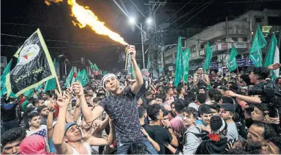  ?? MAHMUD HAMS AFP VIA GETTY IMAGES ?? Palestinia­ns in Gaza City celebrate the ceasefire brokered by Egypt between Israel and Hamas early Friday.